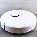 Een moderne robotstofzuiger aan het werk op een houten vloer, ideaal voor efficiënt schoonmaken.